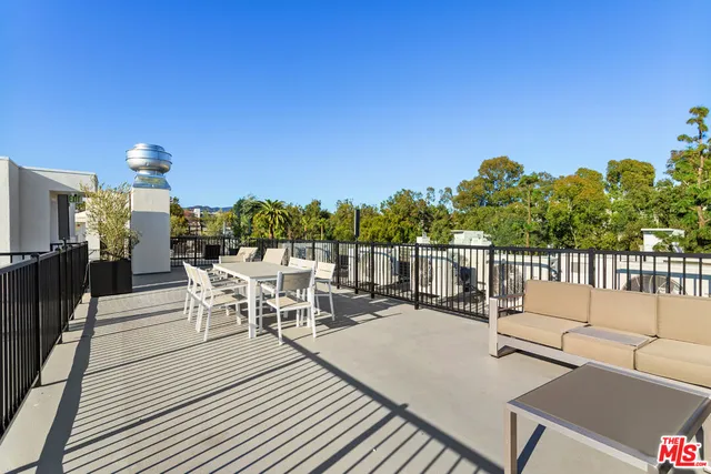 a view of a patio with a dining table and chairs with wooden floor