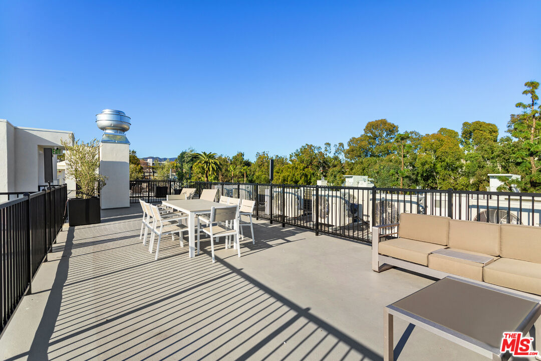 11620 Chenault Street, Unit 103 Los Angeles, CA 90049 - Photo 20 of 21 a view of a patio with a dining table and chairs with wooden floor