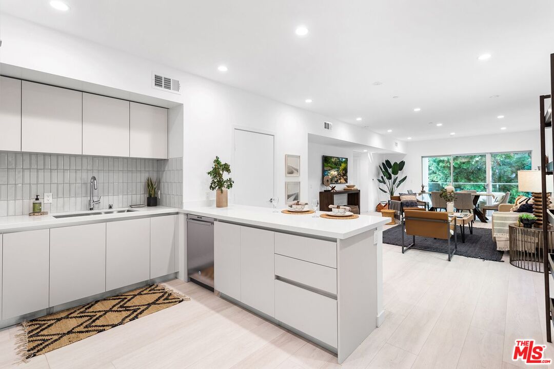 11620 Chenault Street, Unit 103 Los Angeles, CA 90049 - Photo 2 of 21 a large white kitchen with lots of counter top space