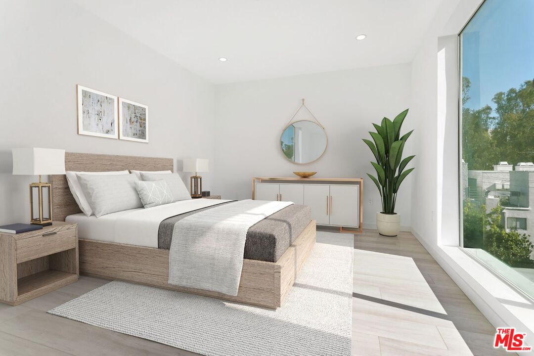 11620 Chenault Street, Unit 103 Los Angeles, CA 90049 - Photo 8 of 21 a bedroom with a large bed and a potted plant