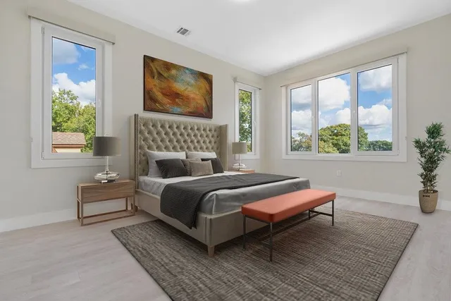 a bedroom with a bed wooden floor and window