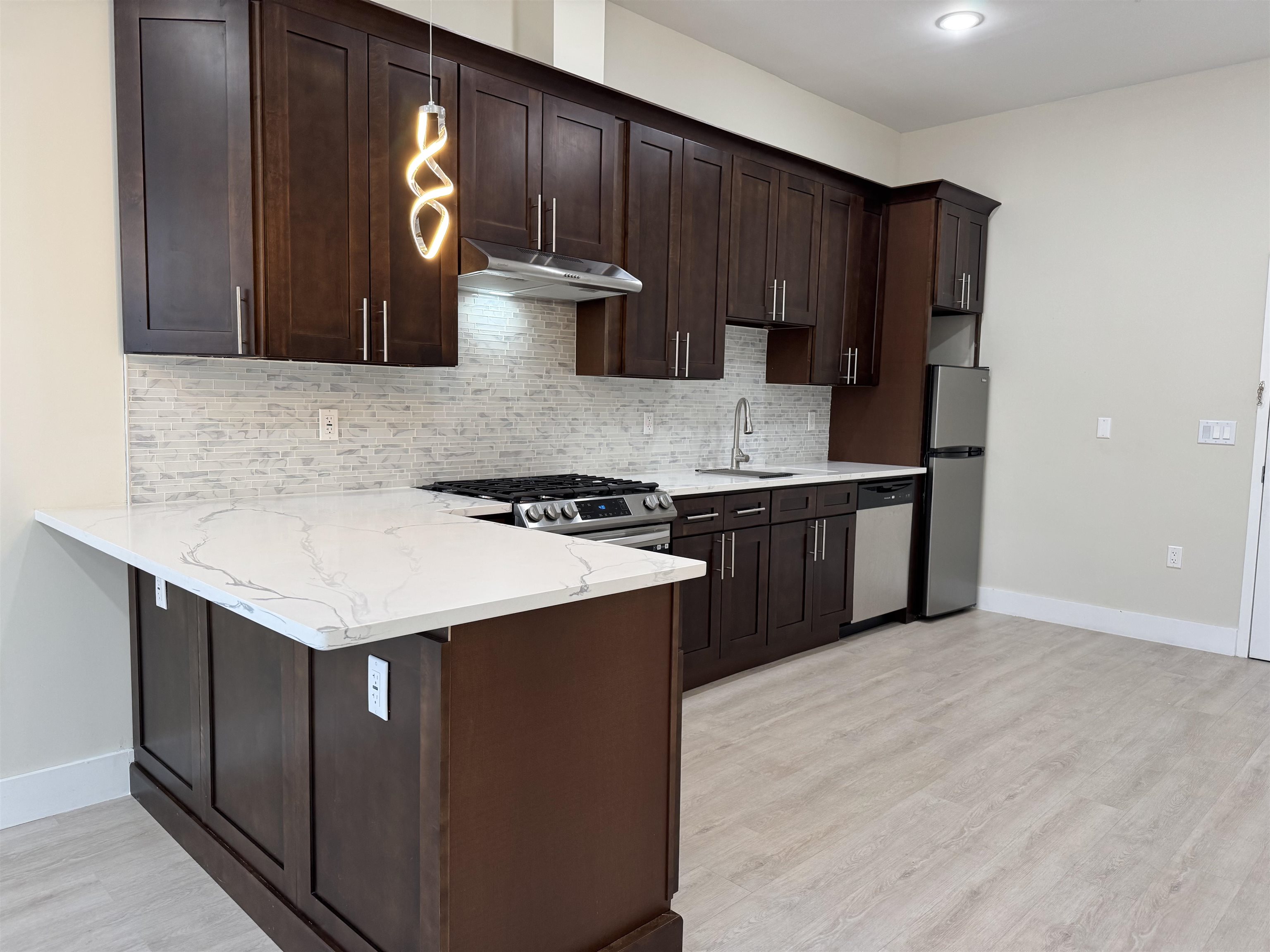527 Union Avenue, Unit 1D Belleville, NJ 07109 - Photo 5 of 17 a kitchen with stainless steel appliances granite countertop a stove a refrigerator and a sink with wooden cabinets