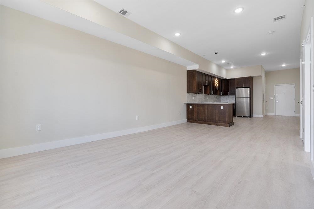 527 Union Avenue, Unit 1D Belleville, NJ 07109 - Photo 6 of 17 an empty room with kitchen and windows