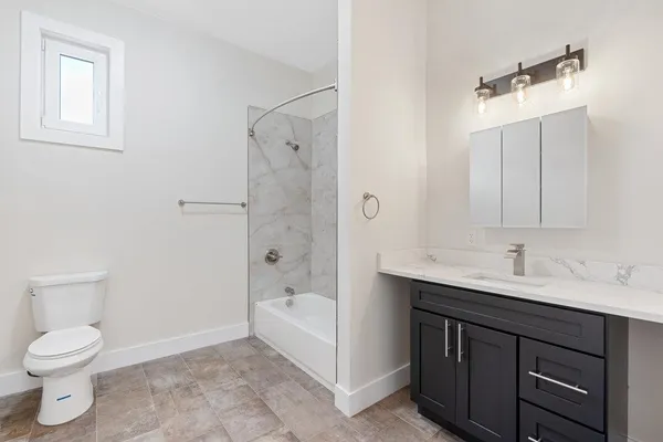 a bathroom with a sink a toilet and shower