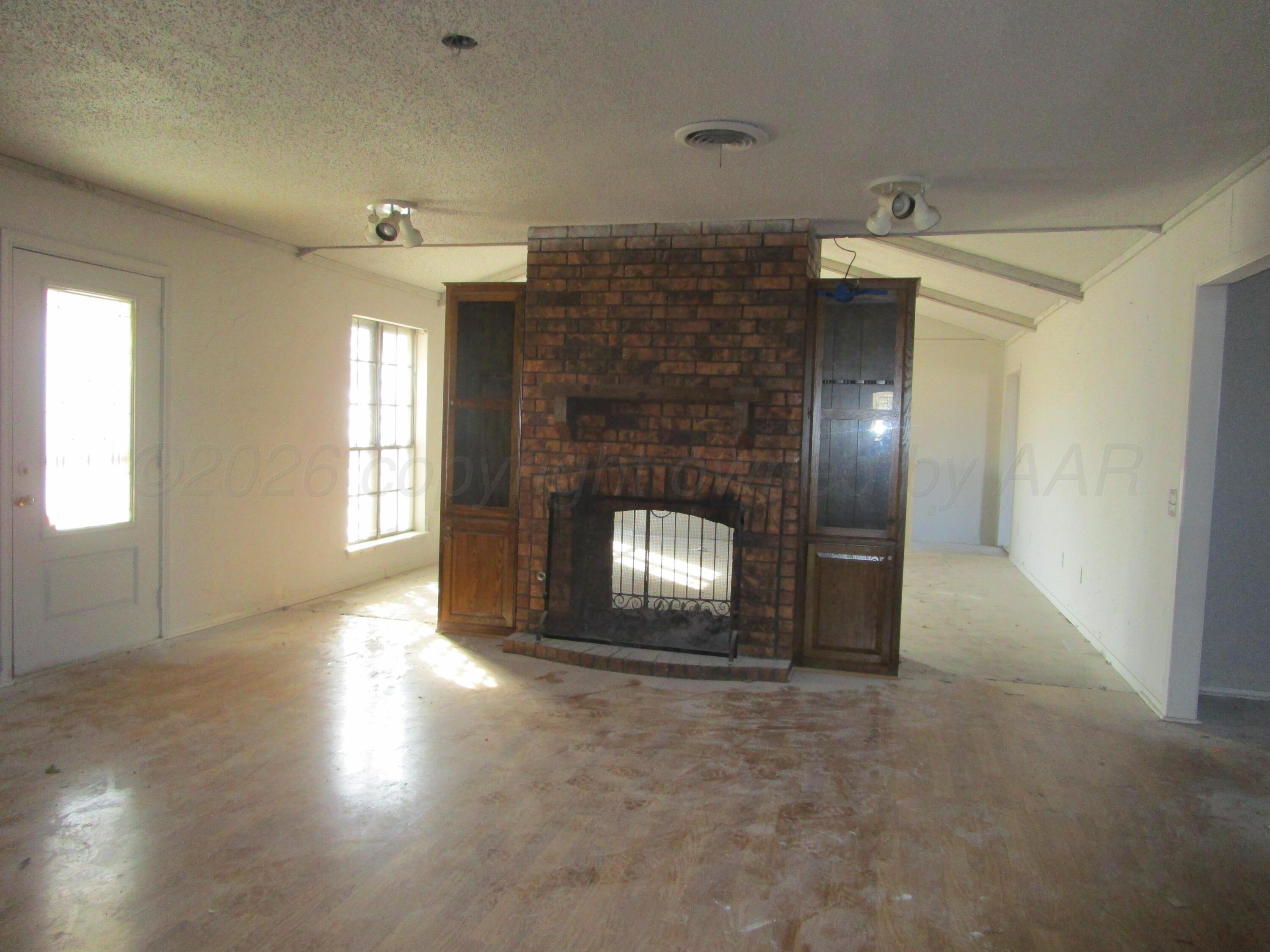 601 Alamo Street Claude, TX 79019 - Photo 16 of 30 an empty room with windows and fireplace