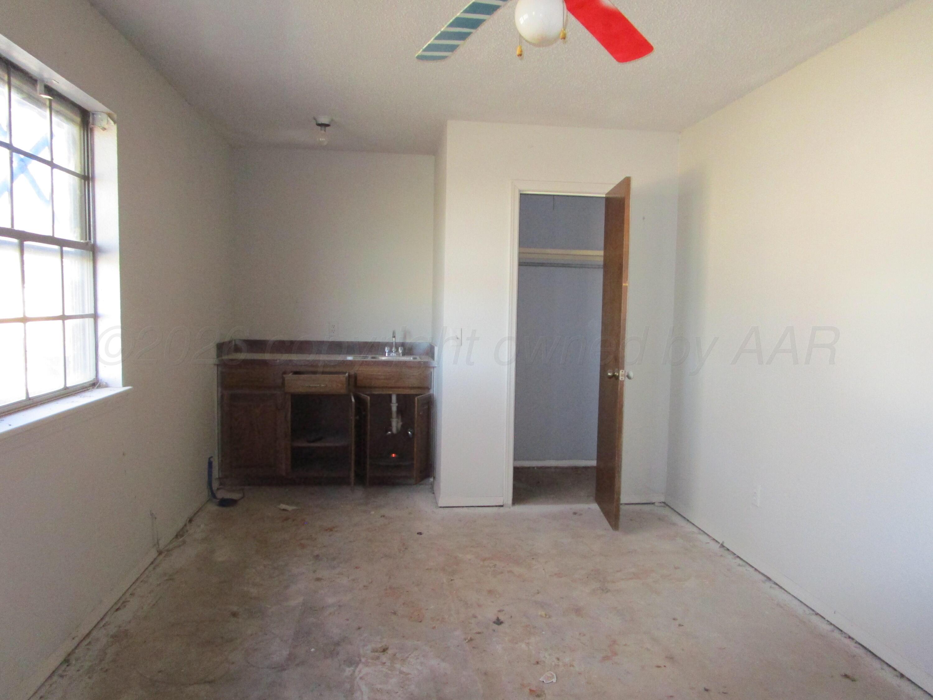 601 Alamo Street Claude, TX 79019 - Photo 24 of 30 an empty room with a fireplace and cabinet