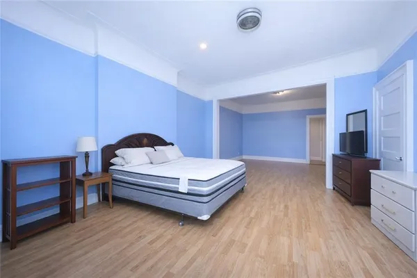 a spacious bedroom with a bed and a dresser