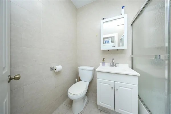 a bathroom with a toilet a sink a mirror and vanity