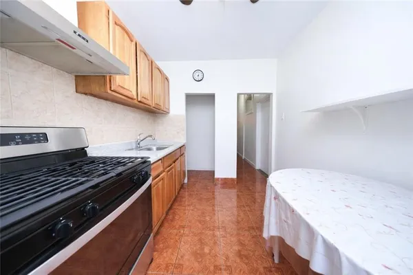 a large kitchen with stainless steel appliances granite countertop a stove and a wooden cabinets