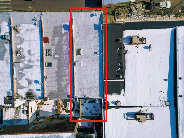 an aerial view of multi story residential apartment building with car parked