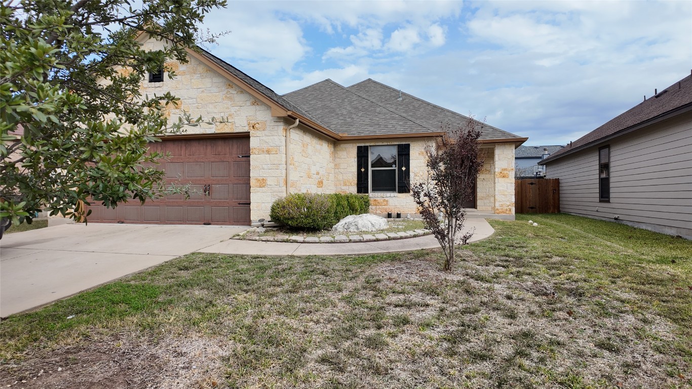 904 Watson Way Pflugerville, TX 78660 - Photo 2 of 16 View of front of home featuring stone siding, a garage, a shingled roof, and driveway