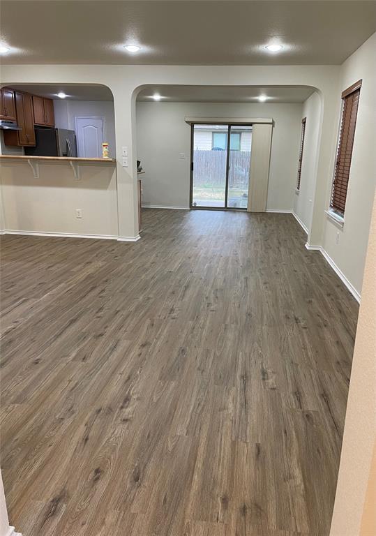 904 Watson Way Pflugerville, TX 78660 - Photo 4 of 16 Unfurnished living room with arched walkways, dark wood-type flooring, and recessed lighting