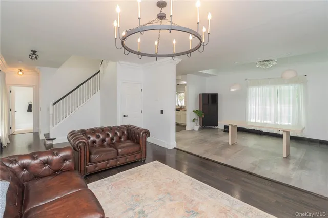 a living room with furniture and a chandelier