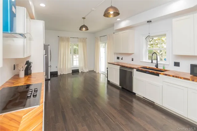 a large white kitchen with a large counter top appliances and cabinets