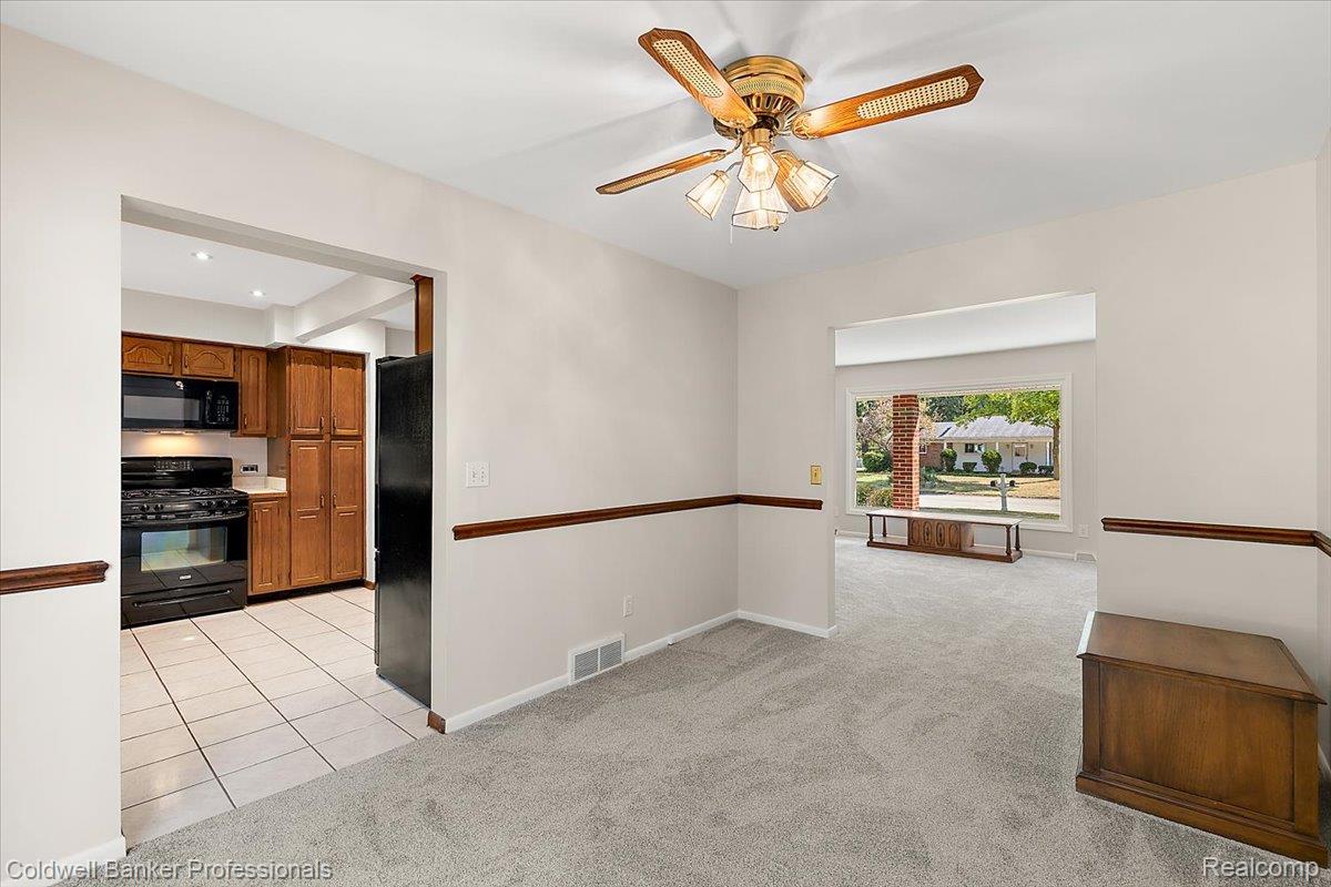 78 Carter Avenue Troy, MI 48098 - Photo 12 of 52 Empty room featuring light colored carpet, light tile patterned floors, and ceiling fan