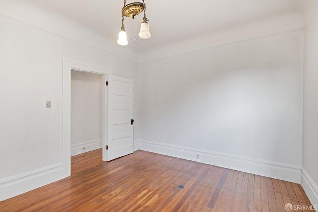 a view of an empty room with chandelier and windows