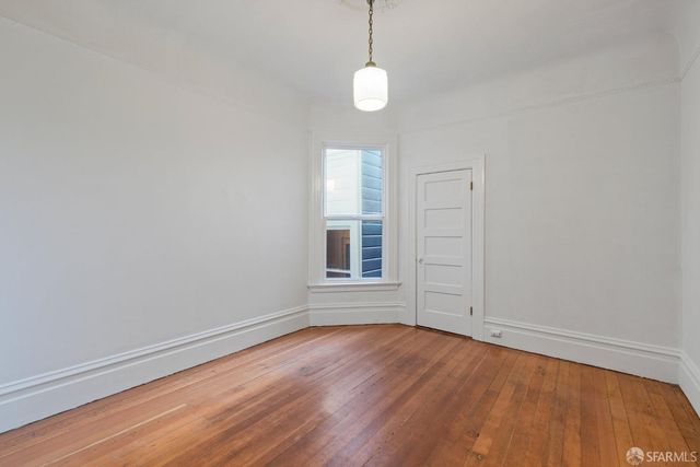 a kitchen with a stove and a wooden floor