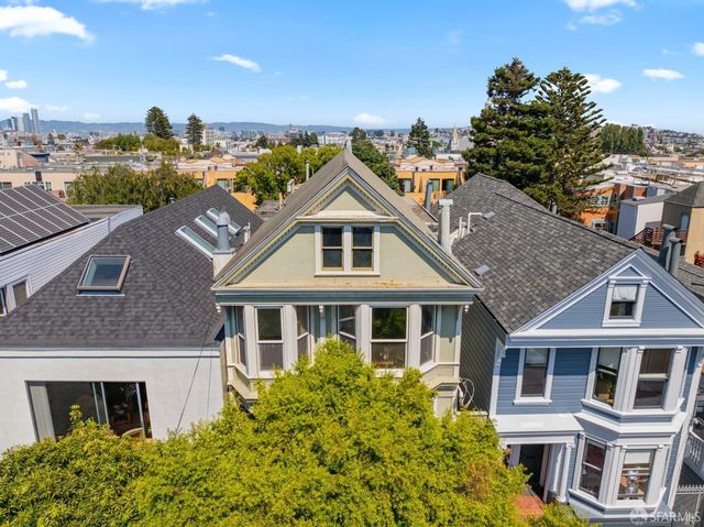 a view of an empty room with wooden floor fireplace and a window