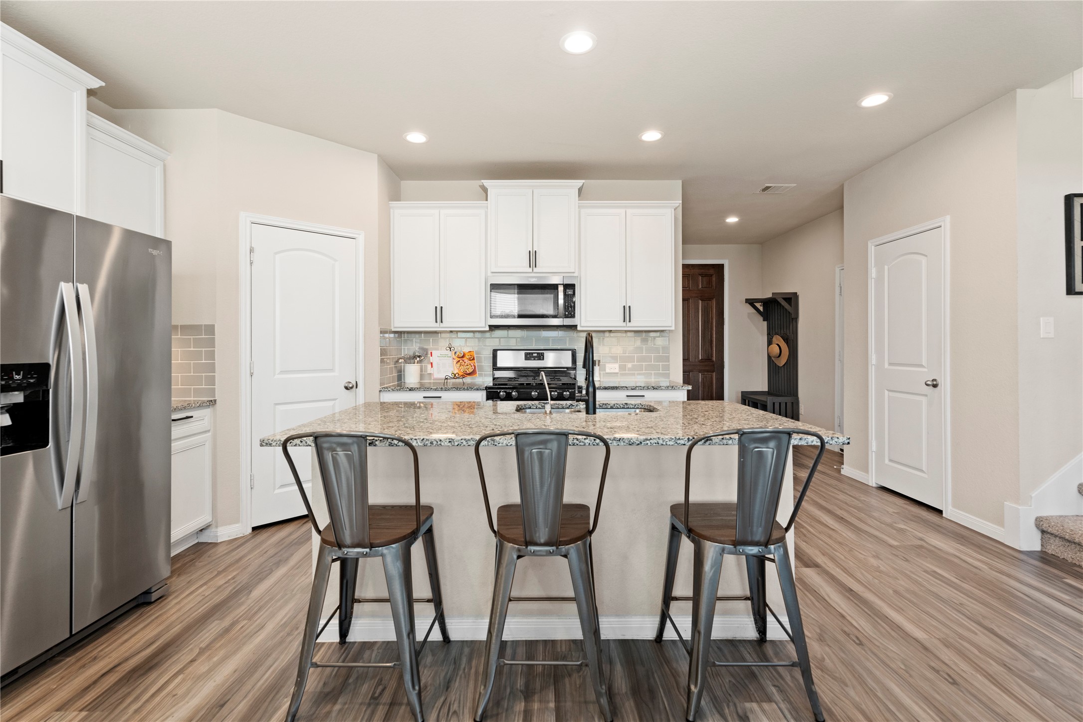 28109 Steepleridge Ct Spring Spring, TX 77386 - Photo 11 of 36 a kitchen with stainless steel appliances granite countertop a dining table chairs refrigerator and sink