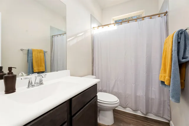 a bathroom with a sink a toilet and shower