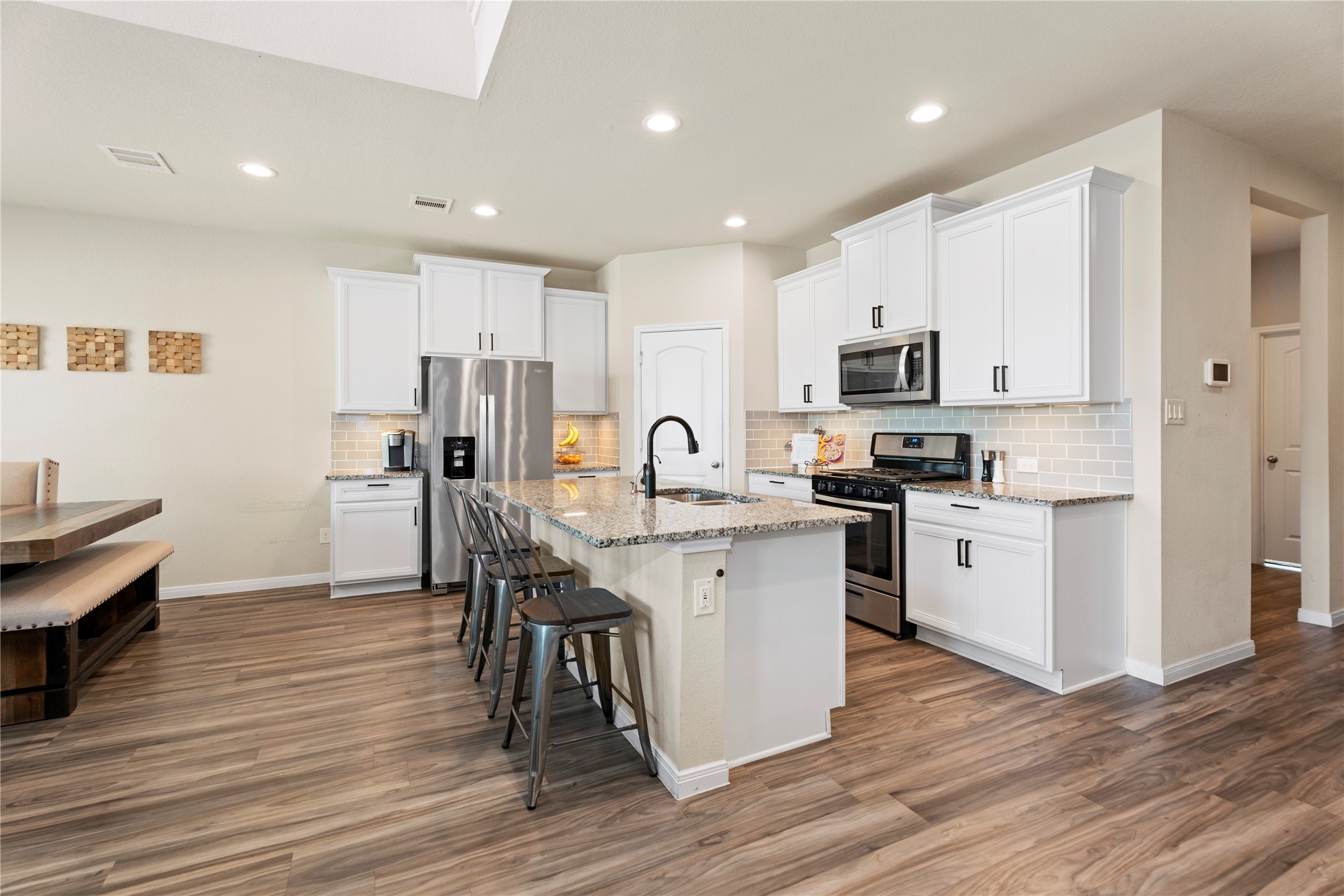 28109 Steepleridge Ct Spring Spring, TX 77386 - Photo 8 of 36 a kitchen with white cabinets stainless steel appliances and wooden floor