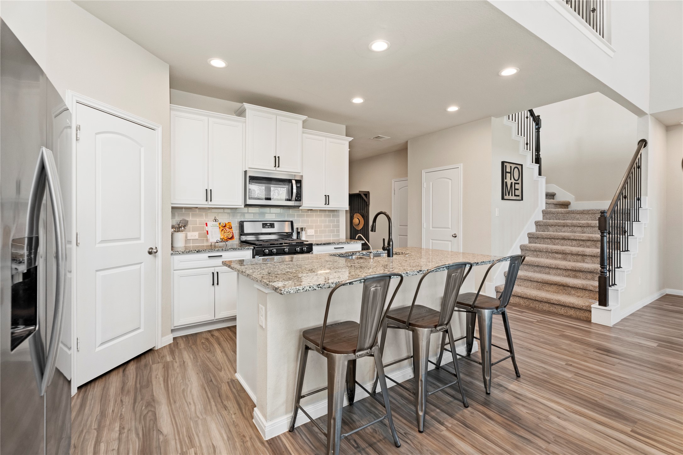 28109 Steepleridge Ct Spring Spring, TX 77386 - Photo 10 of 36 a kitchen with stainless steel appliances white cabinets and wooden floor