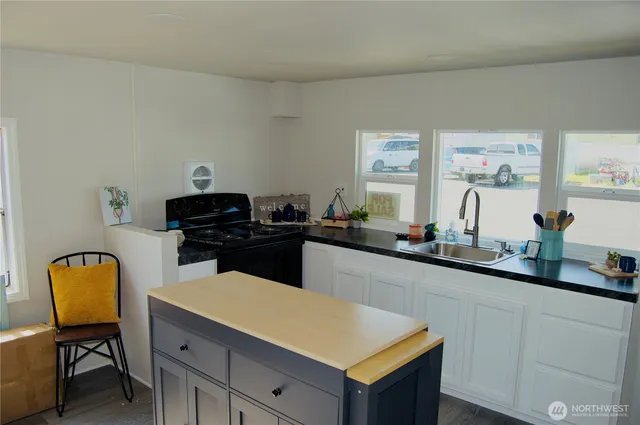 a kitchen with a sink cabinets and chair