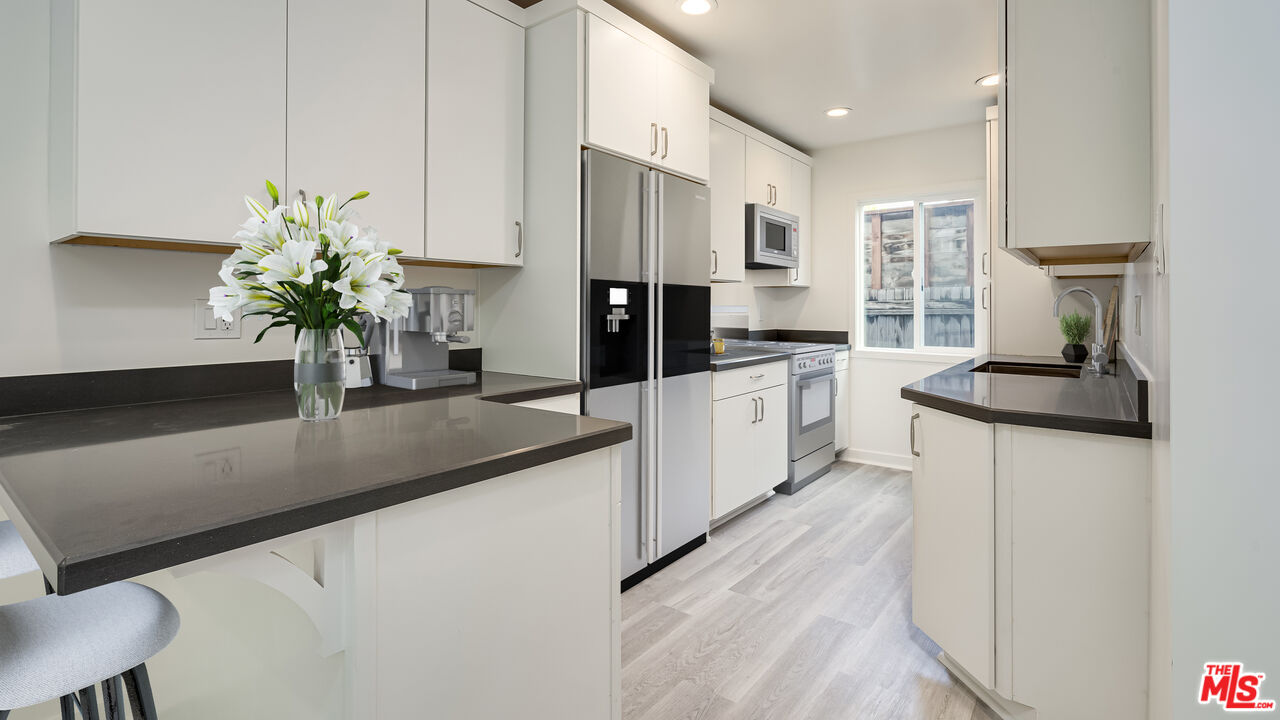 656 Indiana Avenue, Unit 2 Venice, CA 90291 - Photo 6 of 14 a kitchen with stainless steel appliances granite countertop a sink a stove and a refrigerator