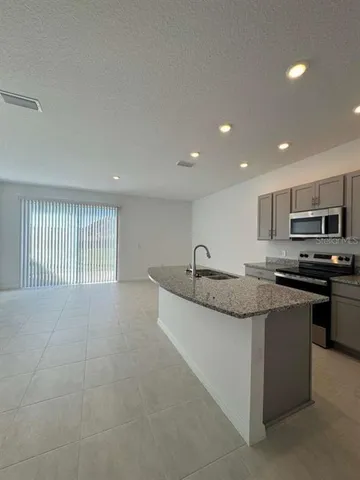 a large kitchen with stainless steel appliances granite countertop a sink and a stove