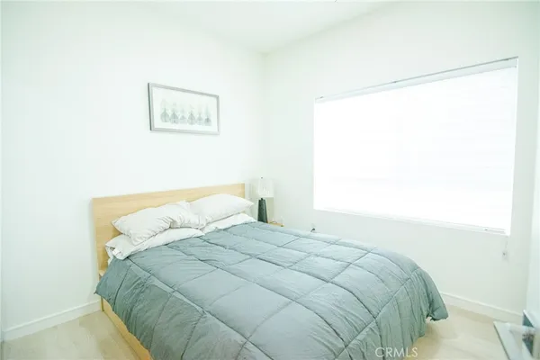 a large bed sitting in a bedroom next to a window