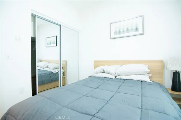 a bedroom with a bed and a mirror