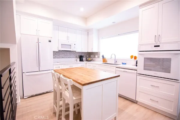 a kitchen with a refrigerator a stove a sink and a cabinets