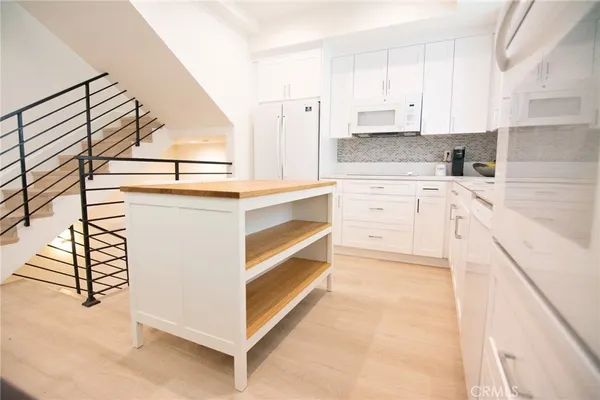 a kitchen with granite countertop white cabinets and white appliances