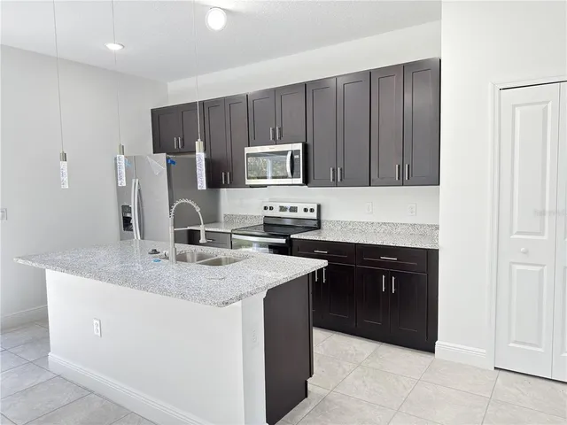 a view of kitchen with refrigerator and microwave