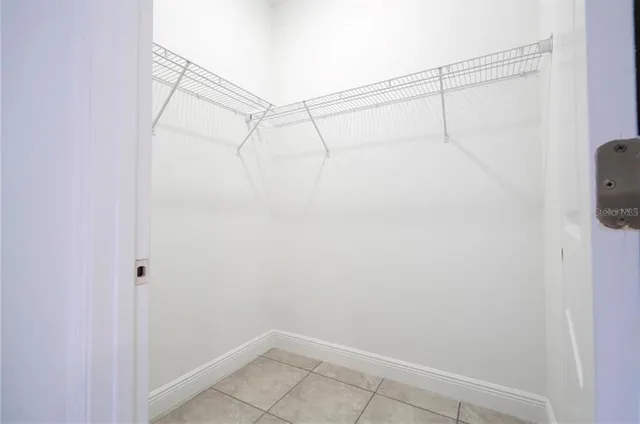 an empty room with a ceiling fan and window