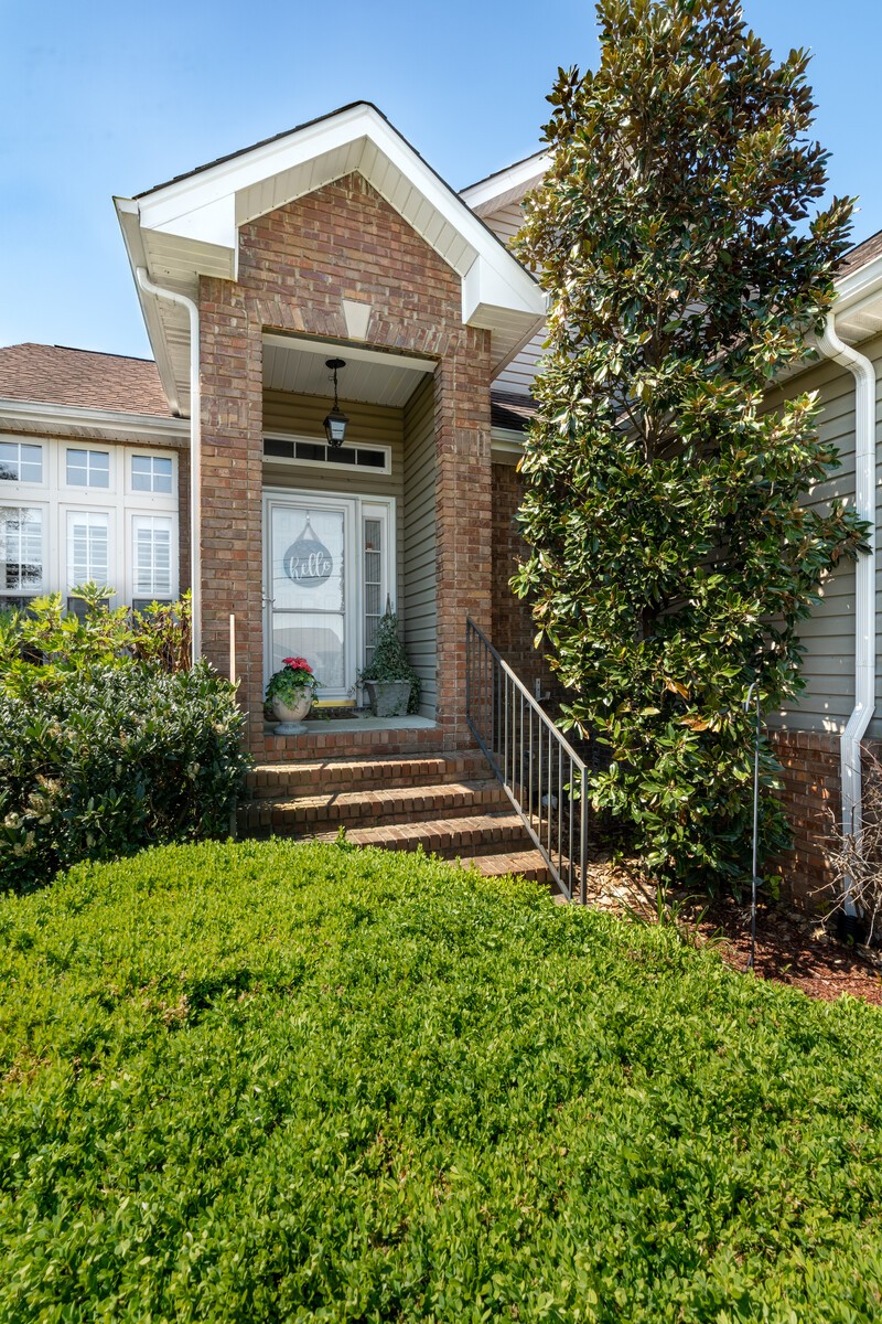 503 Berry Circle Springfield, TN 37172 - Photo 2 of 21 a view of a house with brick walls and a yard with plants and large trees