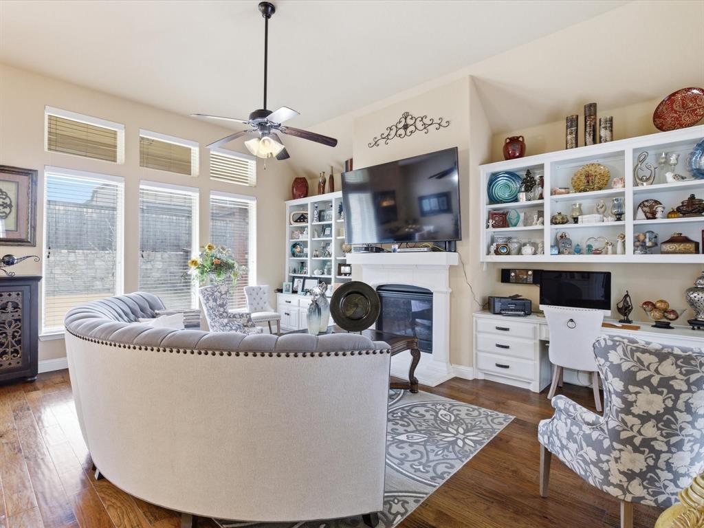 13788 El Toro Road Frisco, TX 75035 - Photo 13 of 29 Living room featuring built in study area, dark wood-style flooring, ceiling fan, and a glass covered fireplace