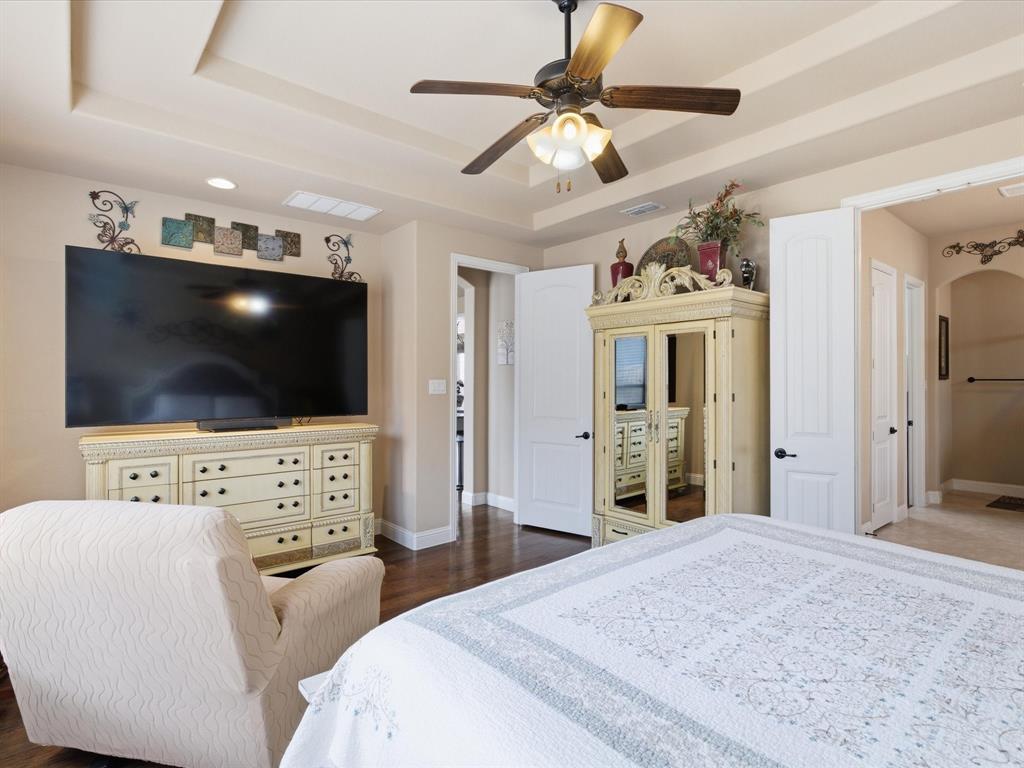 13788 El Toro Road Frisco, TX 75035 - Photo 24 of 29 Bedroom featuring a raised ceiling, a ceiling fan, arched walkways, and dark wood finished floors