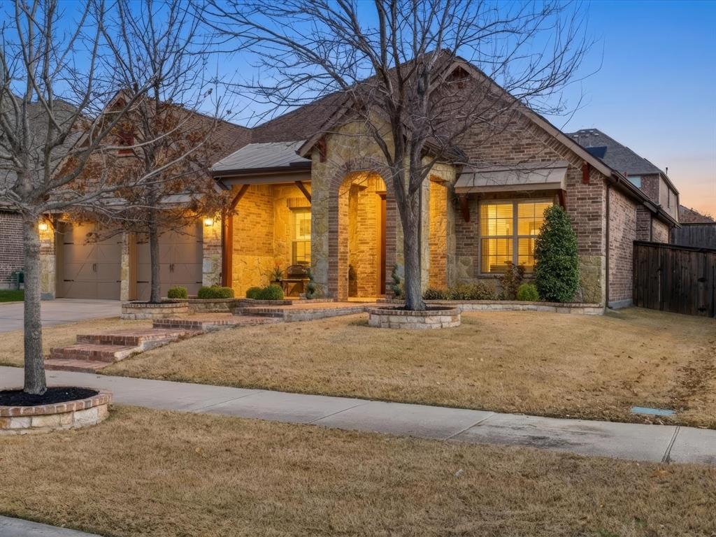 13788 El Toro Road Frisco, TX 75035 - Photo 3 of 29 View of front facade featuring brick siding, a front yard, driveway, and an attached garage