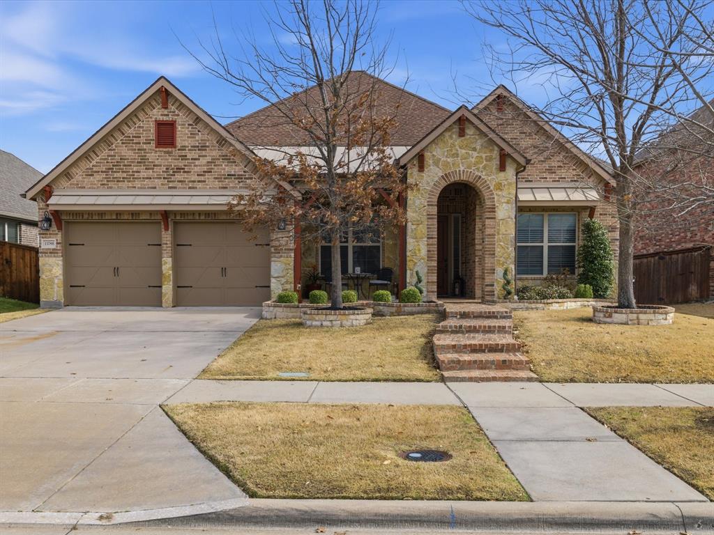 13788 El Toro Road Frisco, TX 75035 - Photo 4 of 29 View of front of home with stone siding, driveway, a garage, and brick siding