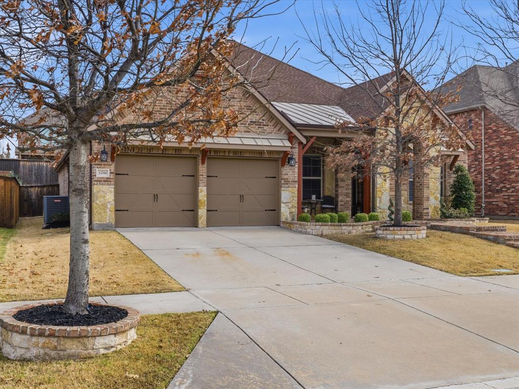 13788 El Toro Road Frisco, TX 75035 - Photo 5 of 29 View of front of property with concrete driveway, stone siding, a garage, and brick siding