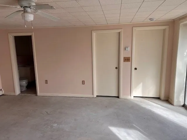 an empty room with a ceiling fan and entryway
