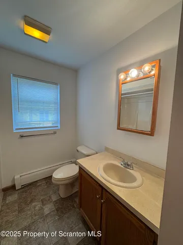 a bathroom with a sink toilet and a window