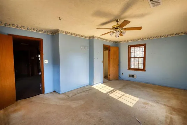 a view of a bedroom with window and ceiling fan