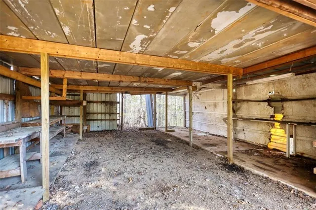 a view of a house with a large tree and wooden fence