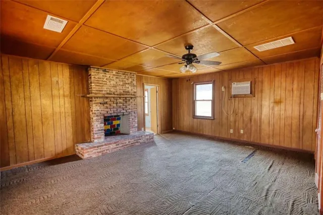 an empty room with windows fireplace and outdoor view