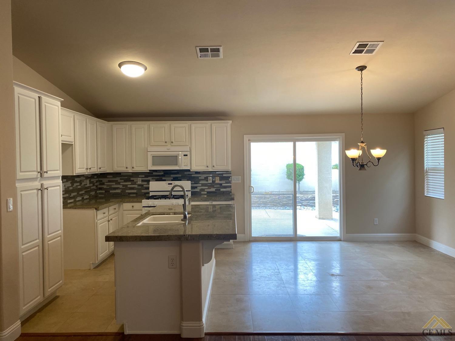 Undisclosed Address Bakersfield, CA 93311 - Photo 5 of 8 a kitchen with kitchen island a counter top space a sink and appliances