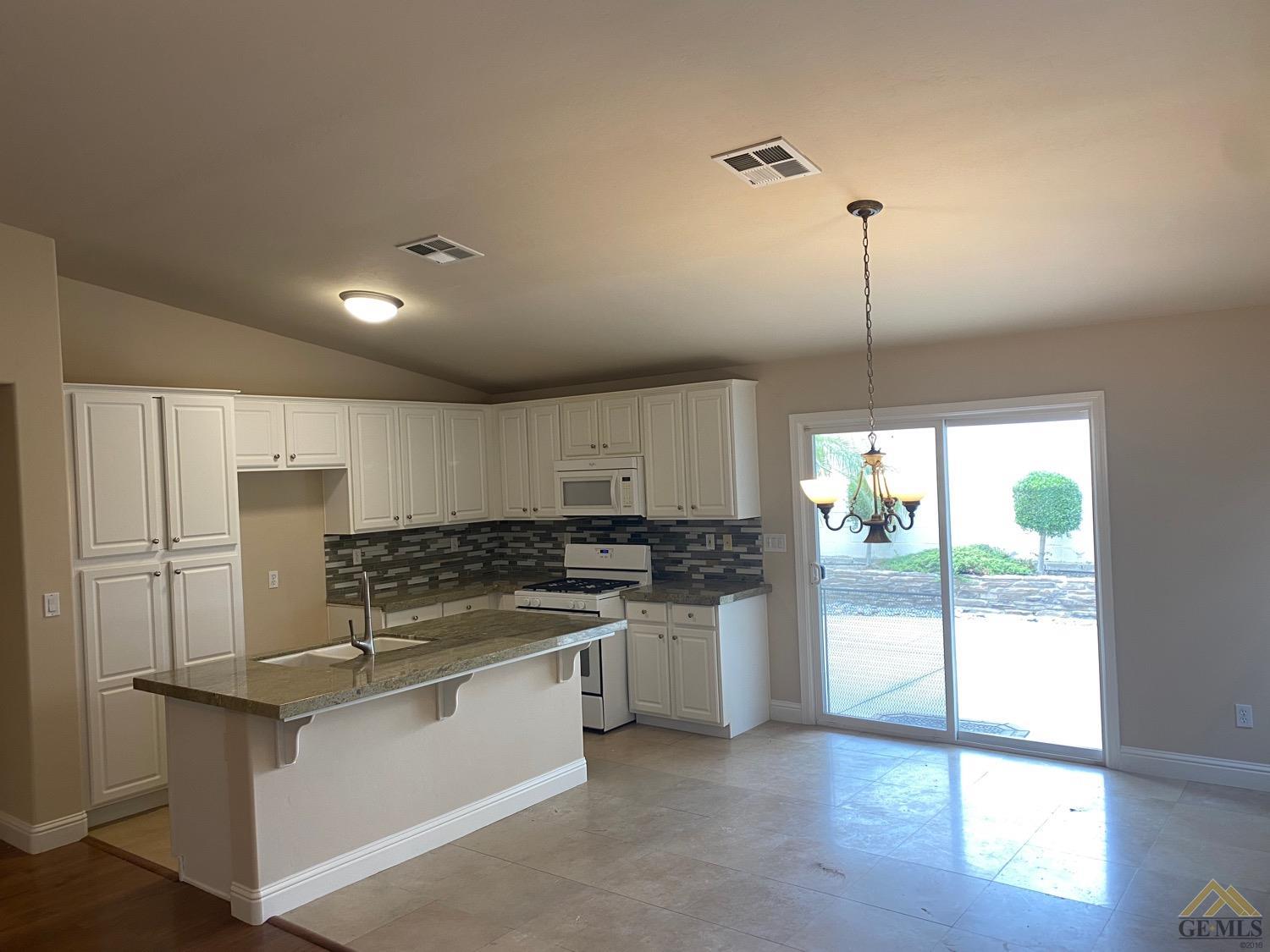 Undisclosed Address Bakersfield, CA 93311 - Photo 6 of 8 a kitchen with a refrigerator a stove top oven and a large window