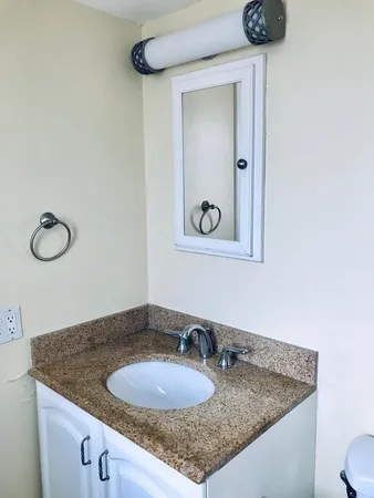 a bathroom with a granite countertop sink and a mirror