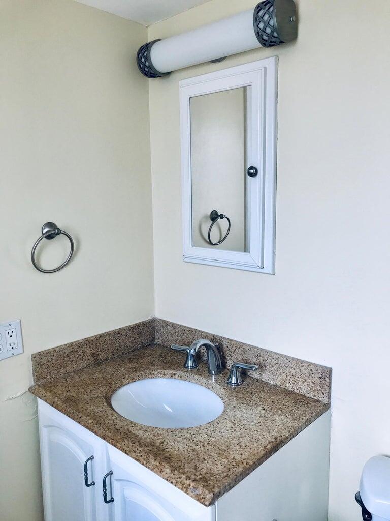 1230 Old Boynton Road, Unit 219 Boynton Beach, FL 33426 - Photo 7 of 12 a bathroom with a granite countertop sink and a mirror